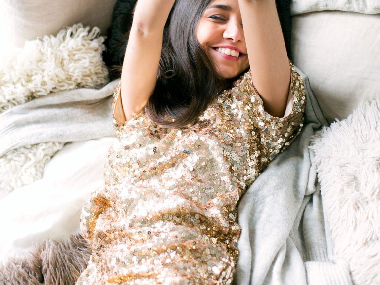 woman-wearing-brown-sequin-dress-laying-on-the-bed-698864